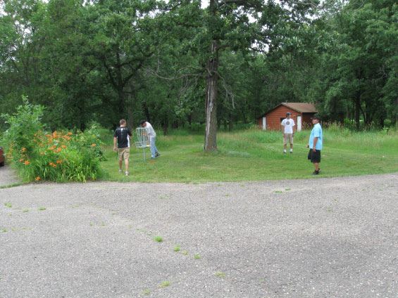 Four men playing disc golf