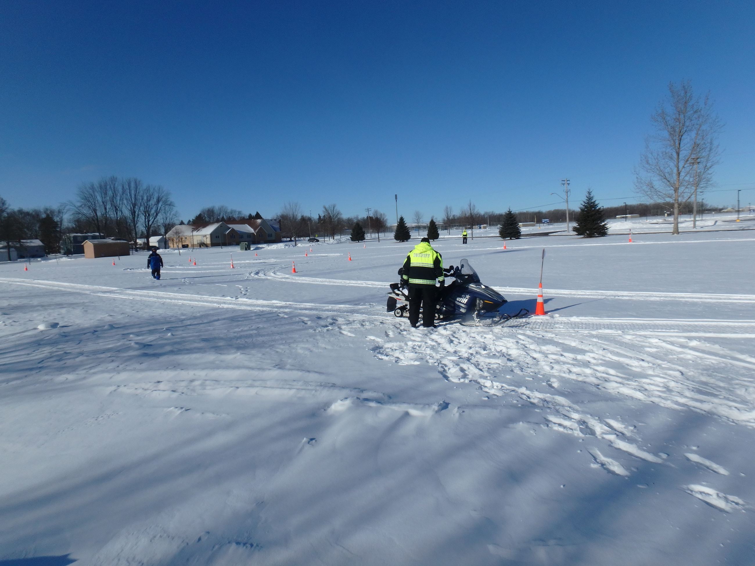Young person riding snowmobile through safety course